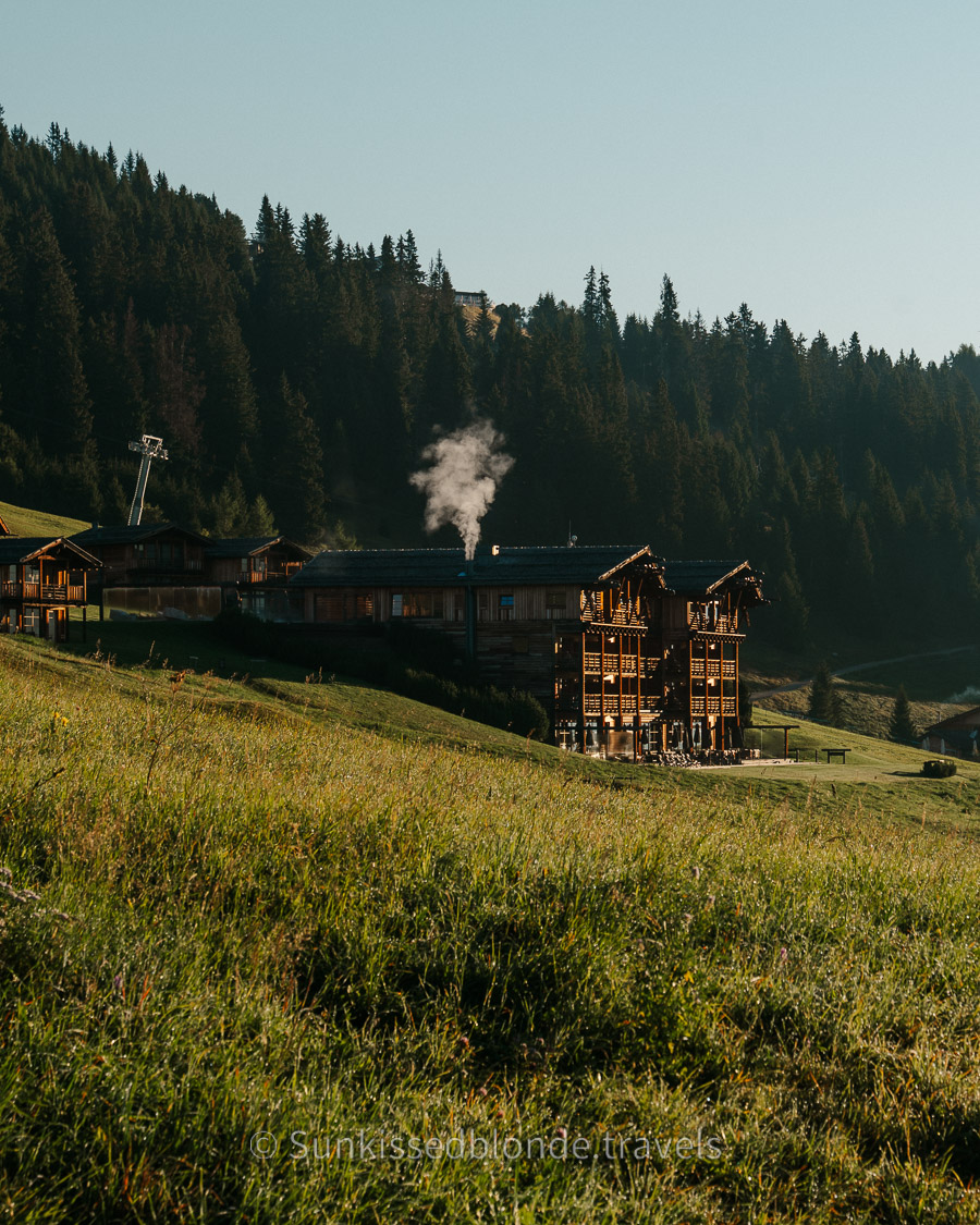 ADLER Spa Resort Alpe exterior at sunrise, luxury alpine hotel on the Alpe di Siusi plateau with Dolomite mountain backdrop, South Tyrol, Italy