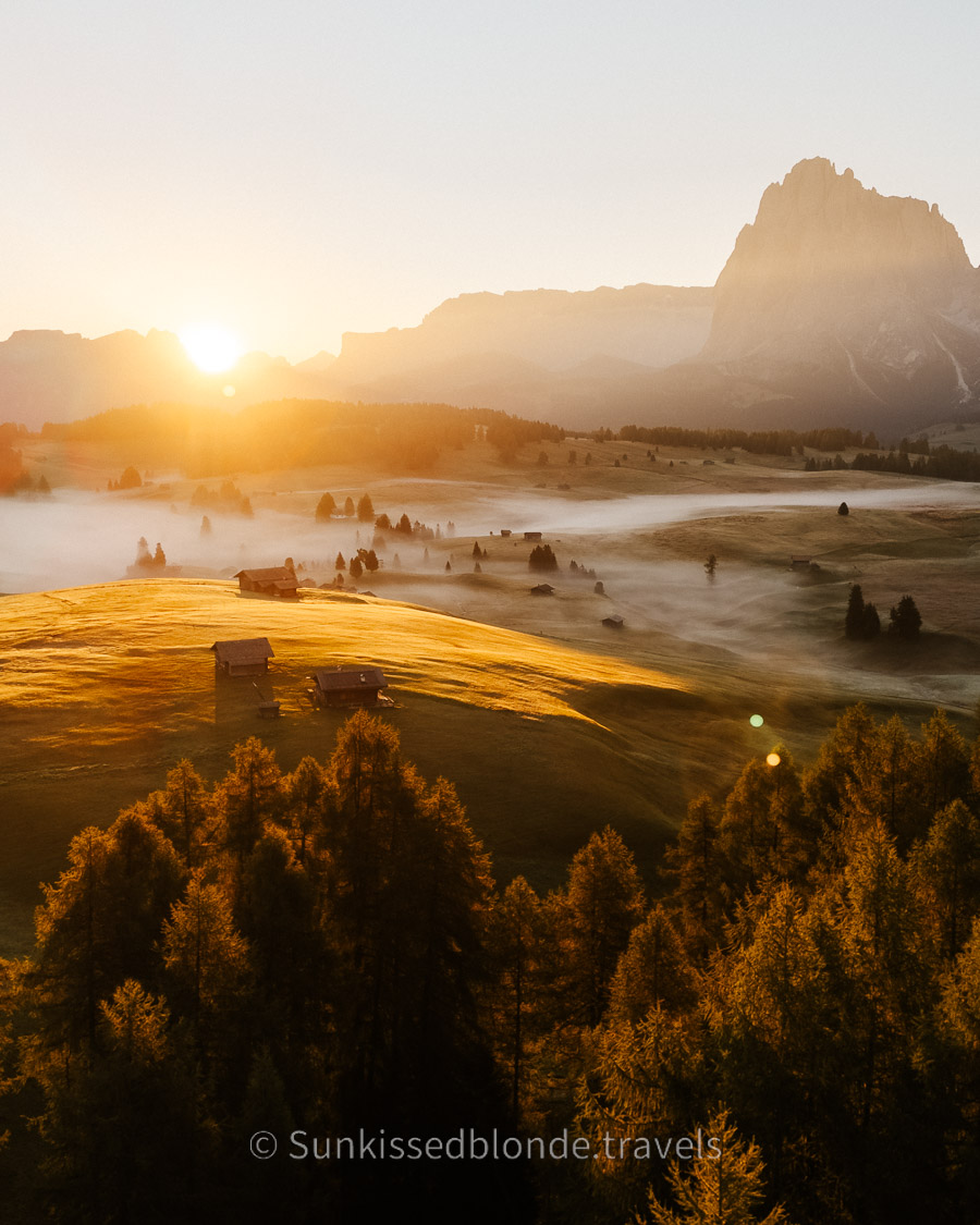 Golden hour light over Alpe di Siusi alpine meadow with Sassolungo mountain peaks in the background, Dolomites, South Tyrol, Italy