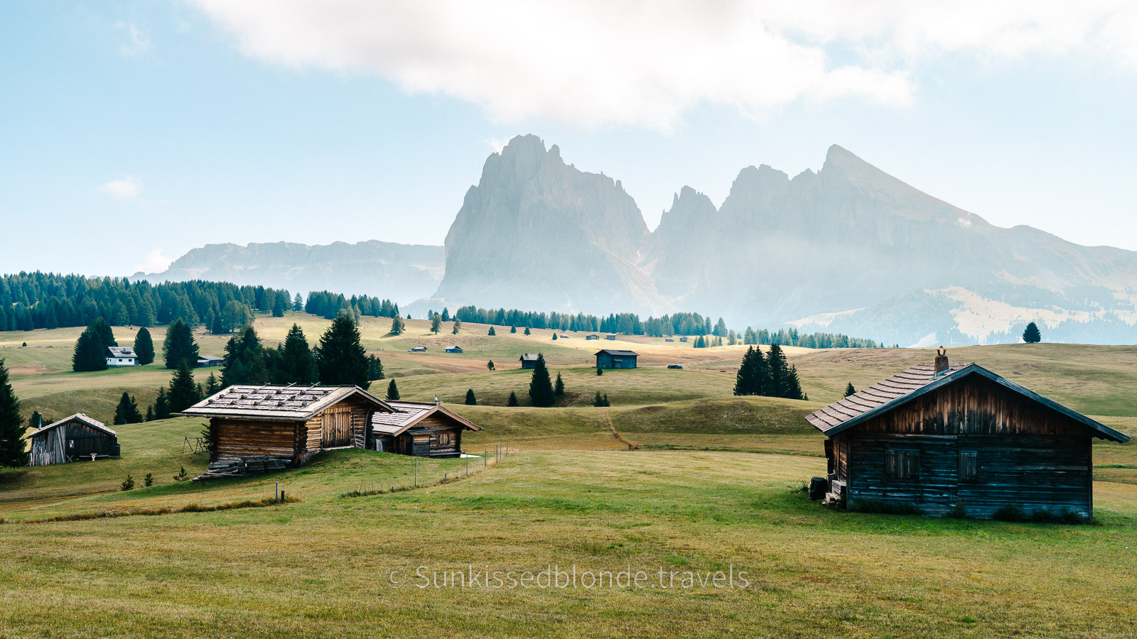 Golden hour light over Alpe di Siusi alpine meadow with Sassolungo mountain peaks in the background, Dolomites, South Tyrol, Italy