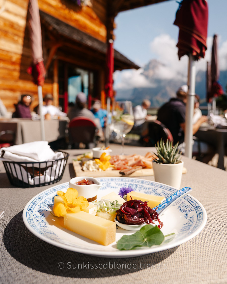 Hikers resting at a traditional mountain h&uuml;tte on Alpe di Siusi with sweeping views across the Dolomites, South Tyrol, Italy