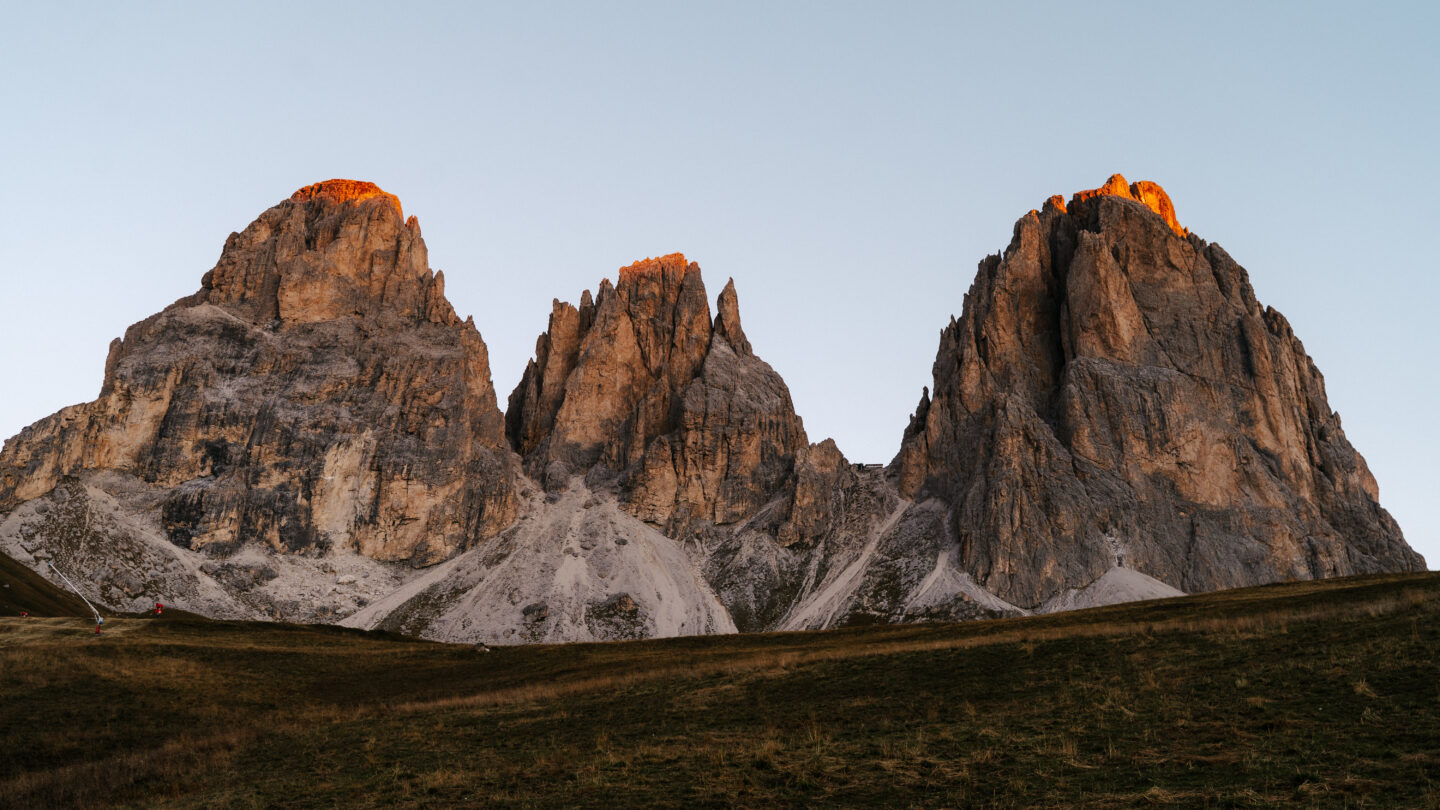 Golden hour light over Alpe di Siusi alpine meadow with Sassolungo mountain peaks in the background, Dolomites, South Tyrol, Italy